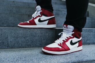 person wearing pair of red-and-white Air Jordan 1 shoes