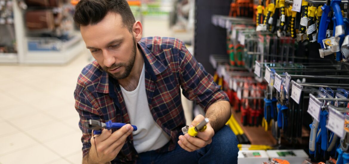 male customer in hardware store chooses pliers