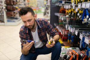 male customer in hardware store chooses pliers