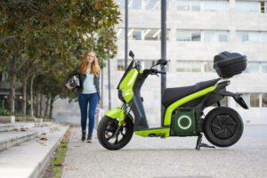 Red-haired woman is going to ride an electric motorbike