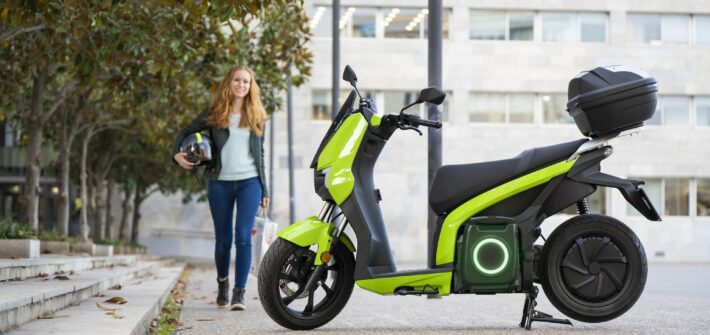 Red-haired woman is going to ride an electric motorbike